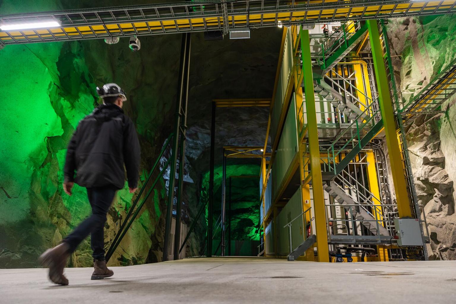 Worker walking towards the server containers at a data centre - lefdal mine